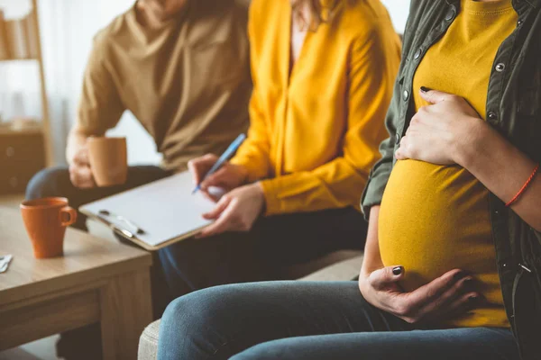 a couple looking at paperwork next to their surrogate gestational carrier